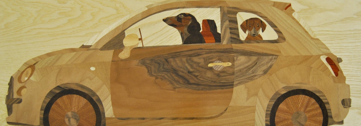 Intarsio ligneo di Capitan Morgan raffigurante una Fiat 500 con una famiglia di bassotti a bordo, realizzato con legni naturali e dettagli in colori acrilici, in stile ironico e affettuoso.