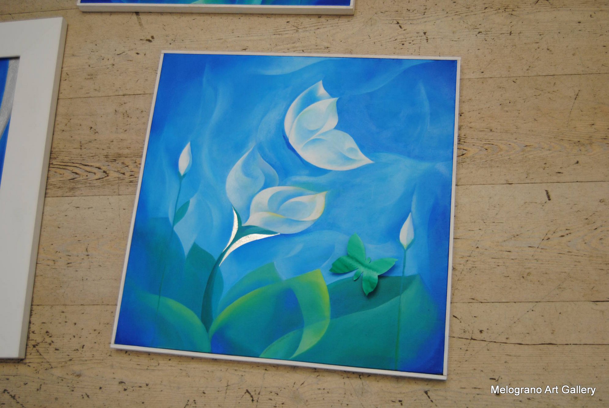 Quadro di Carlotta Pardini con paesaggio onirico etereo, azzurri e verdi intensi, dettagli in rilievo, farfalle, e riflessi di luce