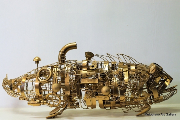 Scultura “Gold Fish” di Marco Cavalieri, pesce dorato realizzato con materiali di riciclo, metallo e componenti meccaniche.