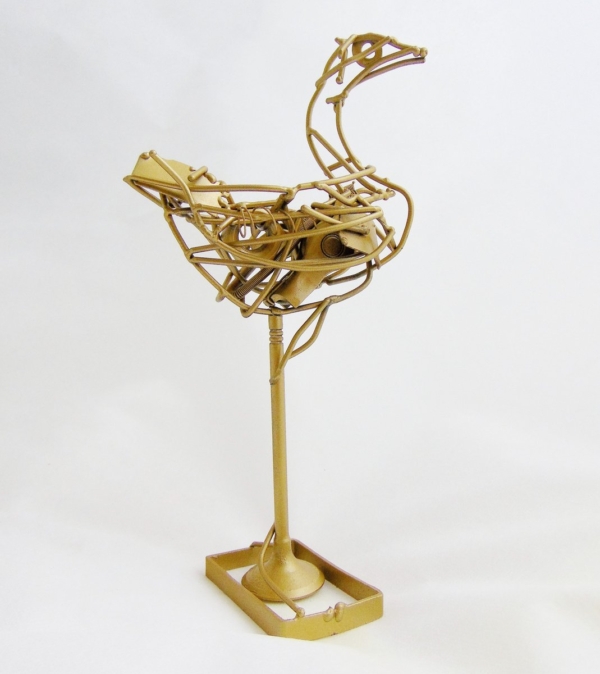 Piccola scultura dorata di Marco Cavalieri in filo metallico con inserti di materiali di riciclo, oggetto poetico e visionario.
