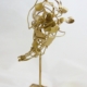 Piccola scultura dorata di Marco Cavalieri in filo metallico con inserti di materiali di riciclo, oggetto poetico e visionario.