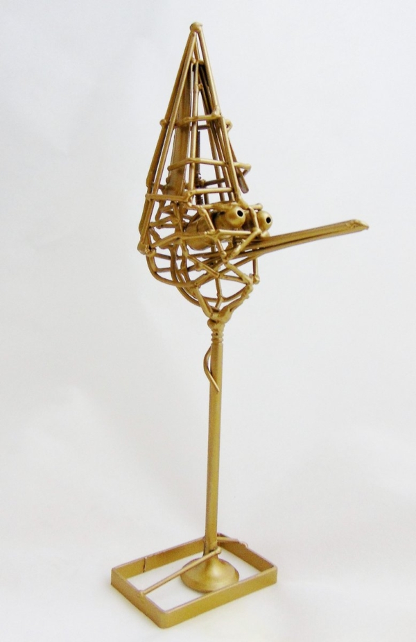 Piccola scultura dorata di Marco Cavalieri in filo metallico con inserti di materiali di riciclo, oggetto poetico e visionario.