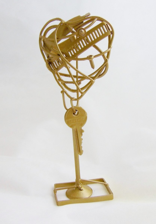 Piccola scultura dorata di Marco Cavalieri in filo metallico con inserti di materiali di riciclo, oggetto poetico e visionario.