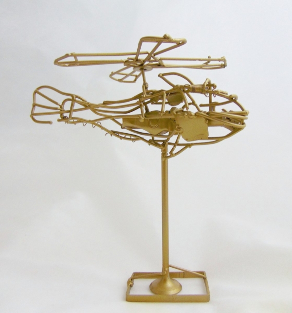Piccola scultura dorata di Marco Cavalieri in filo metallico con inserti di materiali di riciclo, oggetto poetico e visionario.