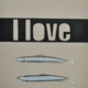 scritta i love su fascia nera con fondo marrone e due acciughine sotto