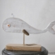 scultura sagomata balena bianca su piedistallo in legno con asta metallica