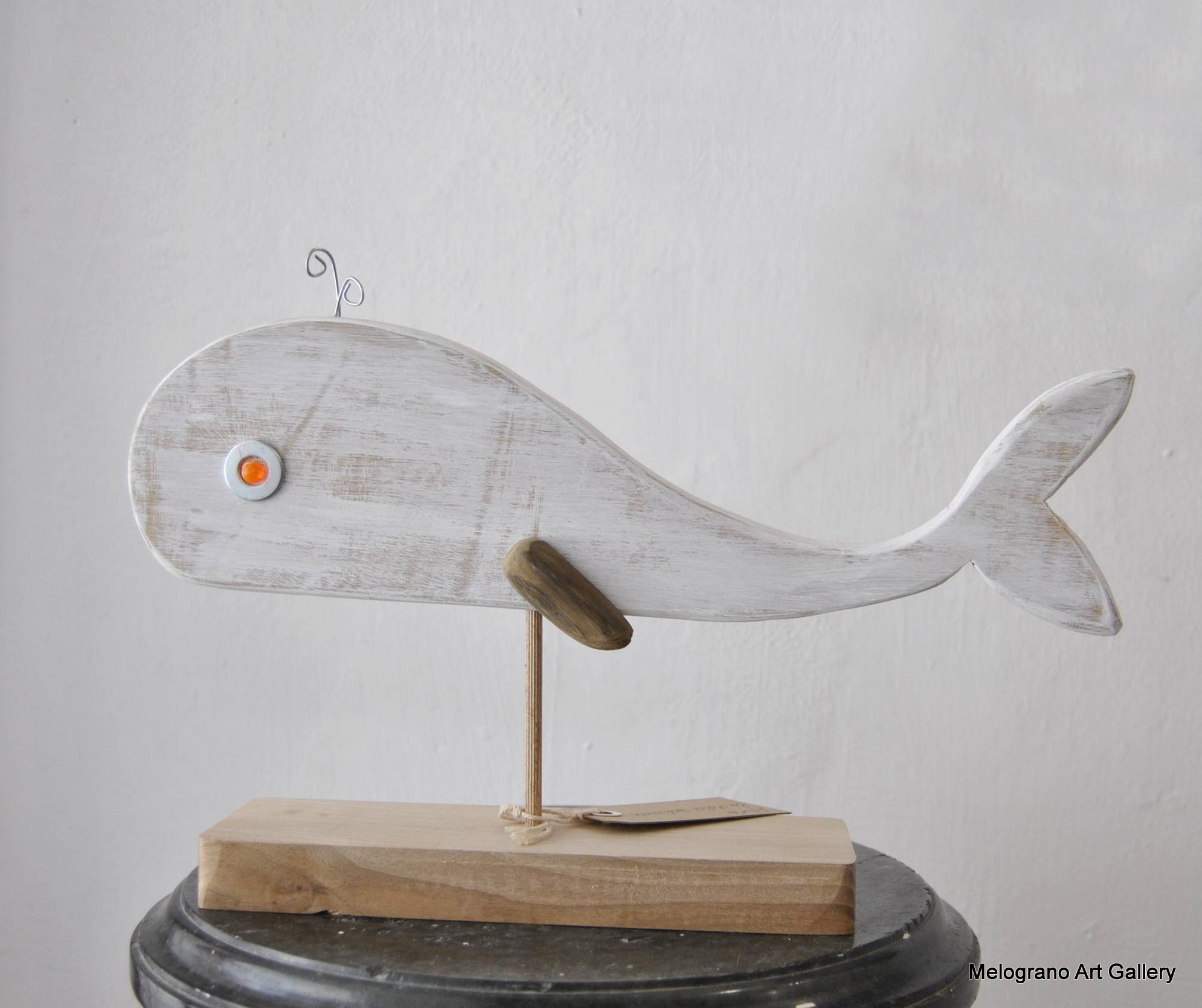 scultura sagomata balena bianca su piedistallo in legno con asta metallica