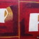 Due tazze bianche con manico giallo, divise da linea verticale su fondo rosso stratificato, serie “Ombre bianche” di Paolo Fidanzi.